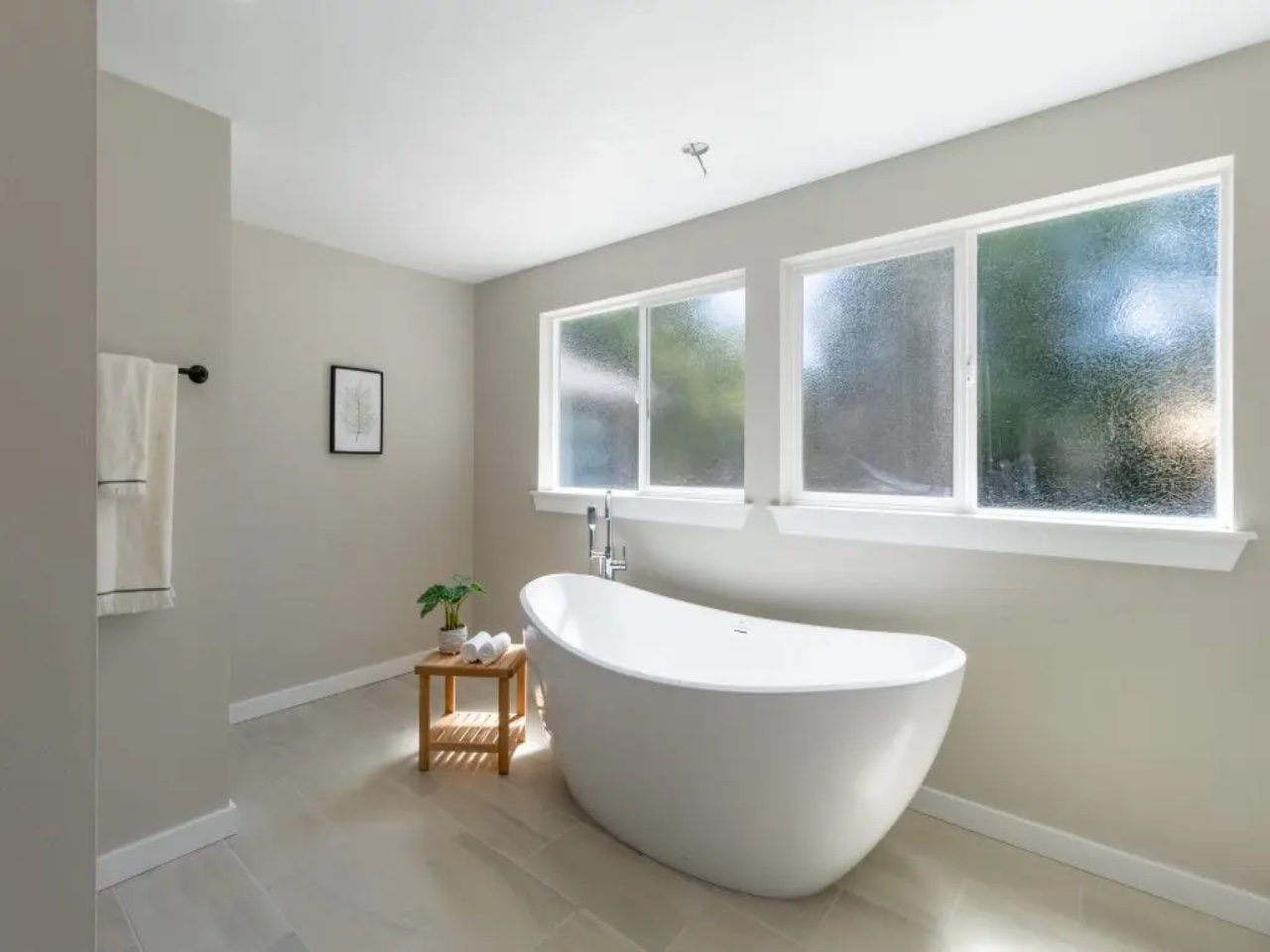 Soaking tub under windows in a remodeled bathroom.
